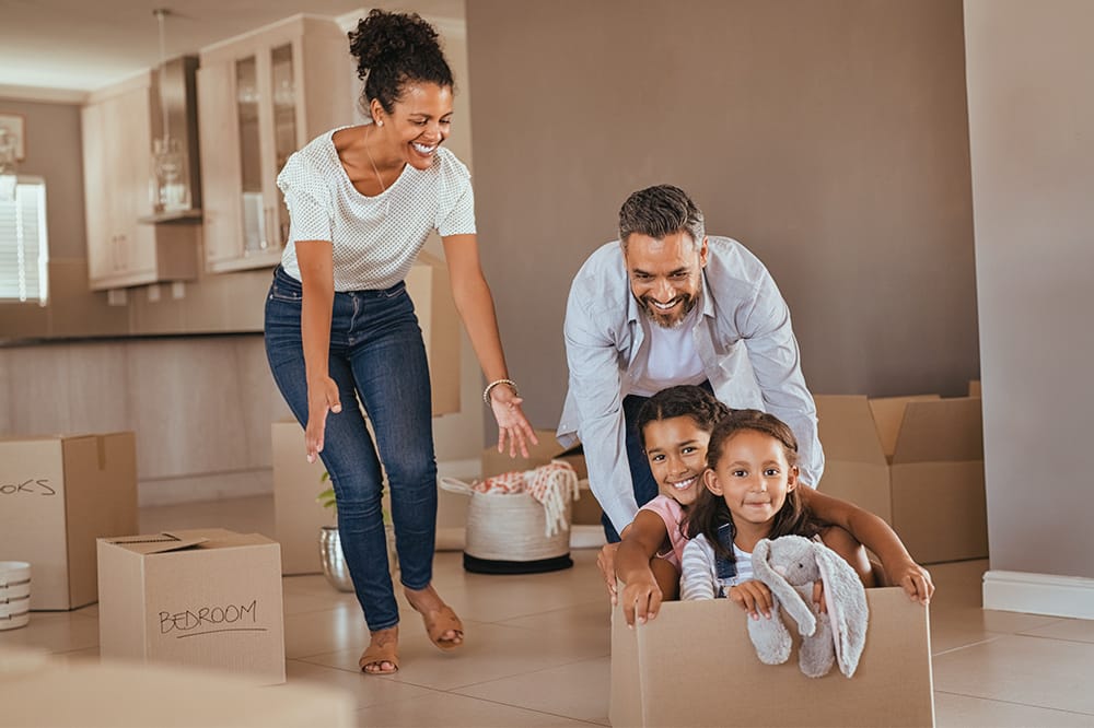 Kids in moving boxes with parents pushing them